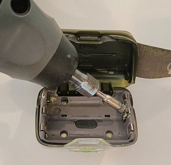 Élimination de la corrosion sur les contacts de la lampe, à l'aide d'un abrasif.