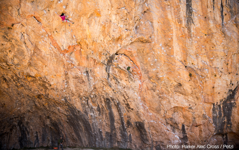 Ashima Shiraishi sending Open Your Mind Direct (9a/+), belayed by her father, in Santa Linya cave. Photo: Parker Alec Cross / Petzl