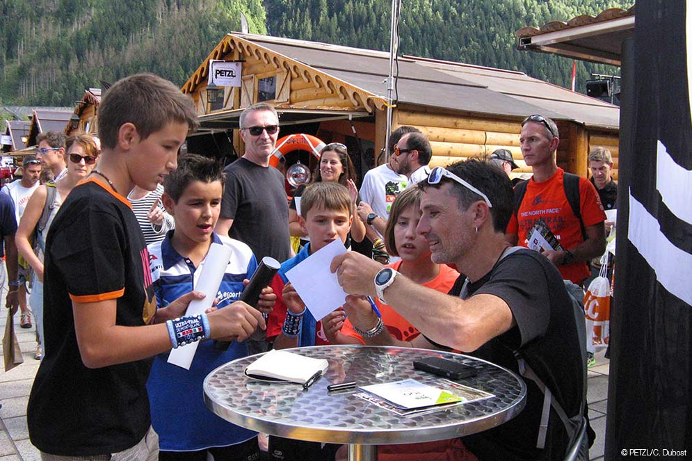 Seb Chaigneau encourage la jeunesse en signant des autographes sur les dossards "mini".